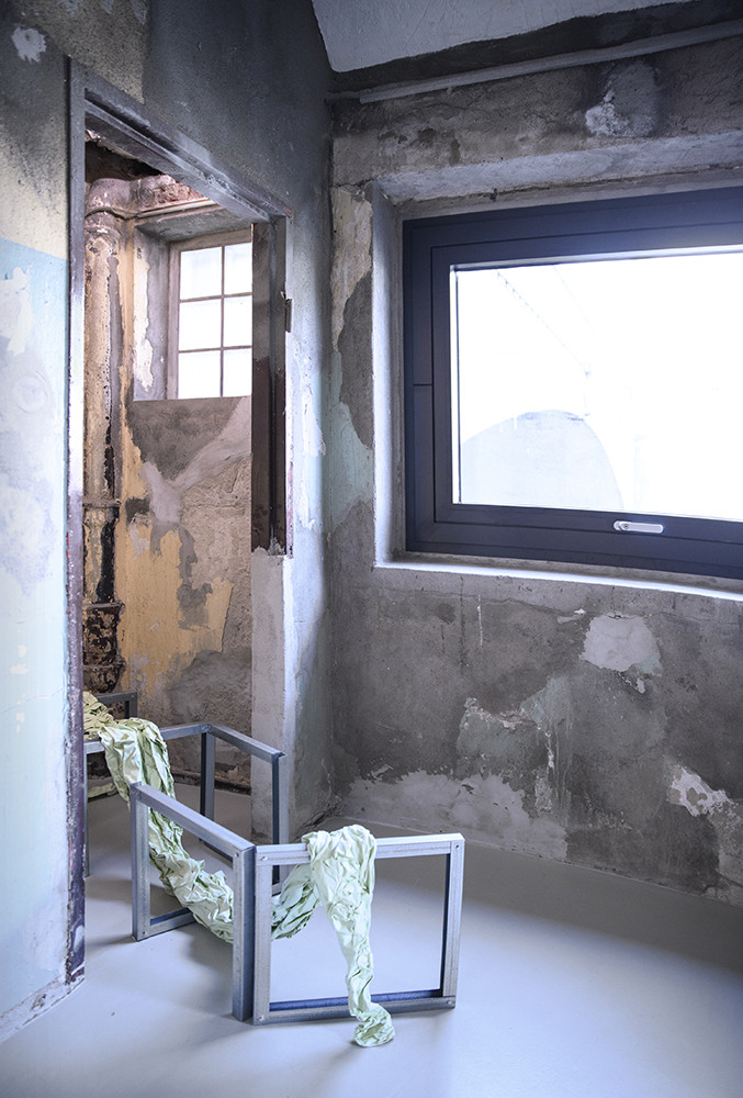 Room view. On the floor is metal scaffolding with a folded cloth.