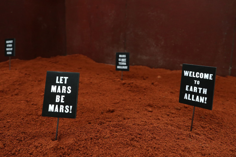 Zeichen stecken in rotem Sand mit der Aufschrift 