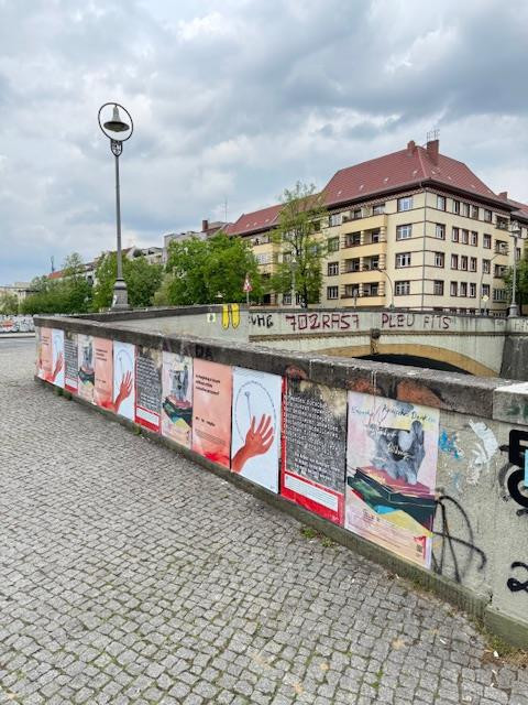 Several protest posters hang side by side on the wall of the Kunstbrücke am Wildenbruch