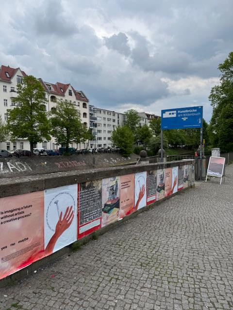 Several protest posters hang side by side on the wall of the Kunstbrücke am Wildenbruch