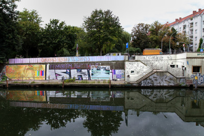 Blick auf eine Anlegestelle am Kanal mit bemalten Wänden.