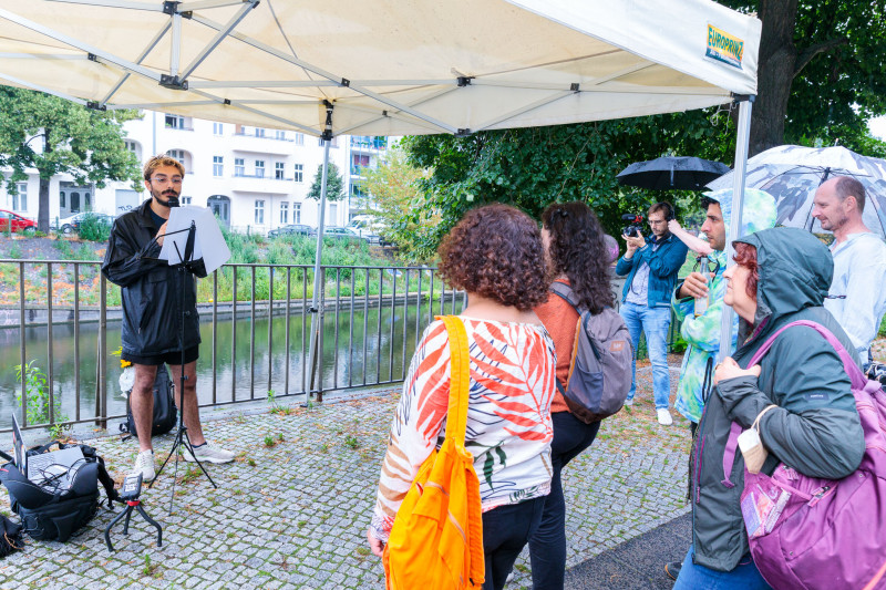 Life Performance. Die Besucher hören dem Sprecher zu. Diren Demir: Speak to the Water, 2022