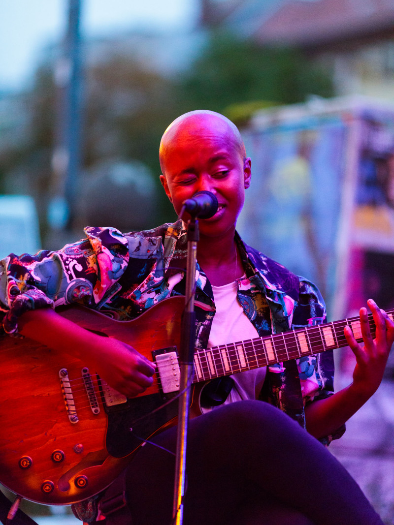 Jamsession. Eine Sängerin mit ihrer Gitarre.
